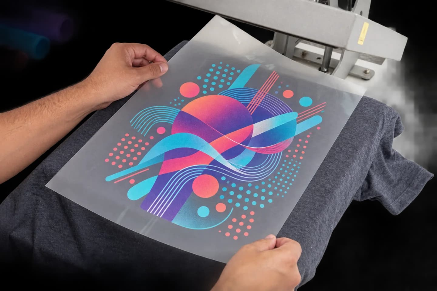 Película DTF con un diseño geométrico posicionada sobre una camiseta gris bajo una prensa
